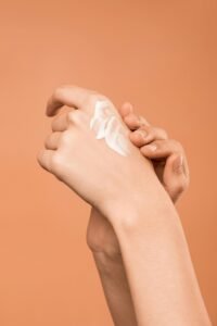 Close-up of hands applying moisturizer, promoting skincare and softness.